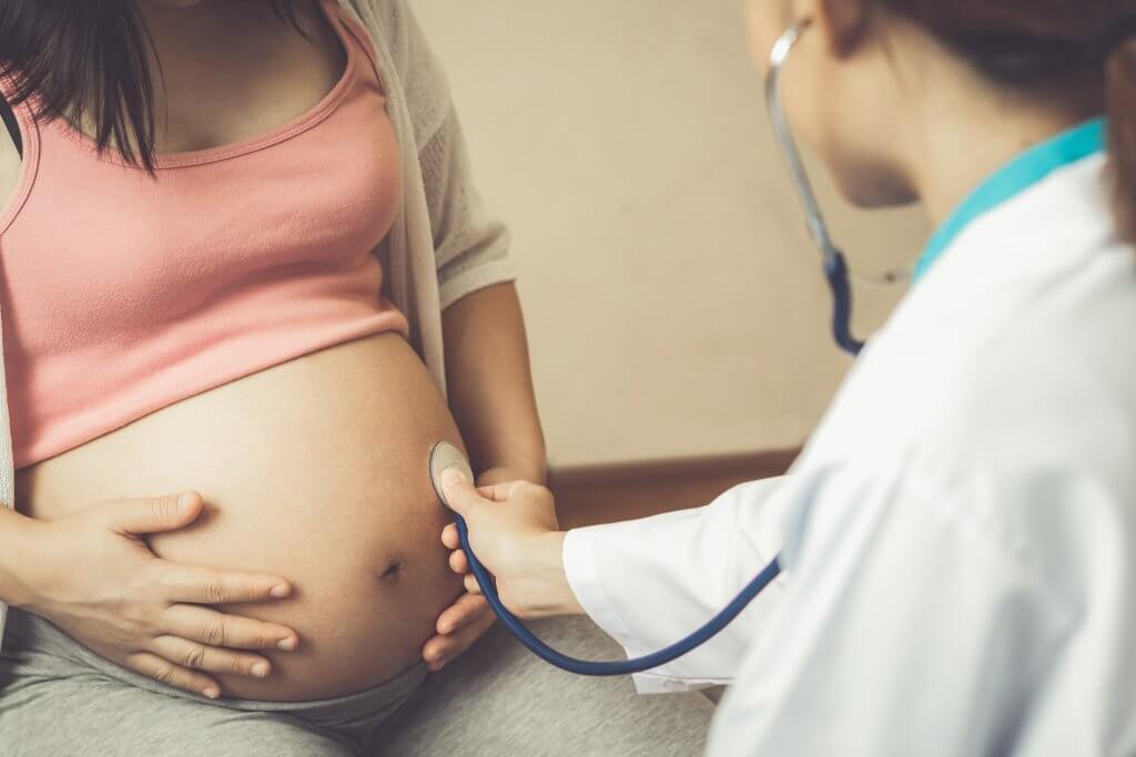 Happy pregnant woman visit gynecologist doctor at hospital or clinic for pregnancy consultant.
